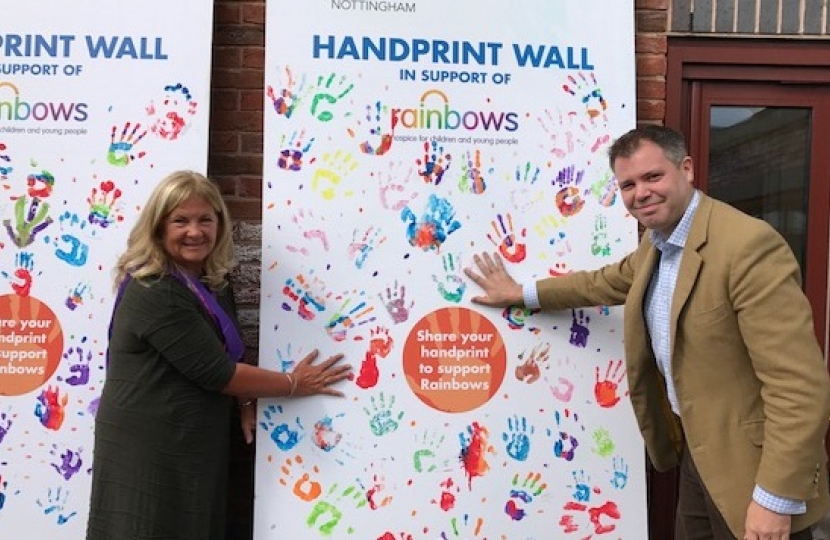 Edward and Rainbows Chair of Trustees hand-print the supporters wall